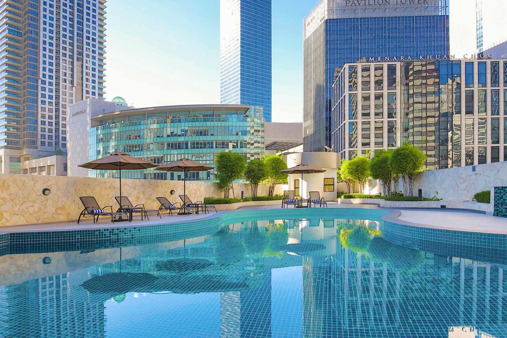 Outdoor pool at Novotel Kuala Lumpur near city skyscrapers.