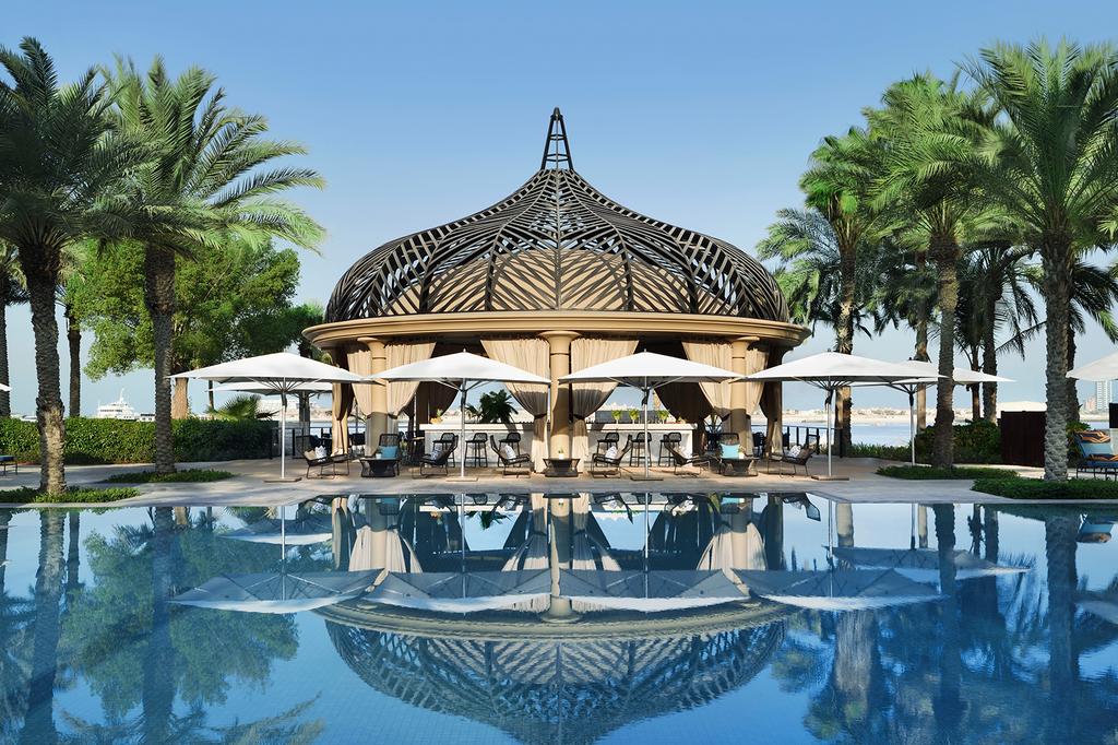 Luxurious pool area with palm trees at One&Only Royal Mirage, Dubai.