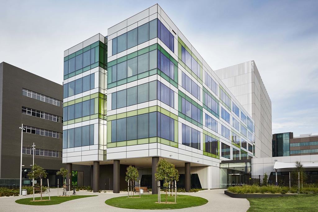 Modern hotel exterior with green and glass accents in Melbourne.