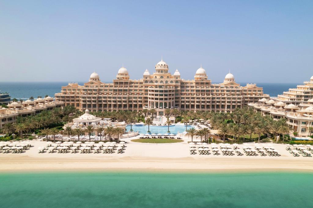 Luxurious Dubai resort on Palm Jumeirah with white sandy beach and palm trees.