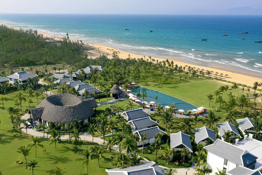 Bliss Hoi An Beach Resort & Wellness with lush gardens and a pool by the sea.