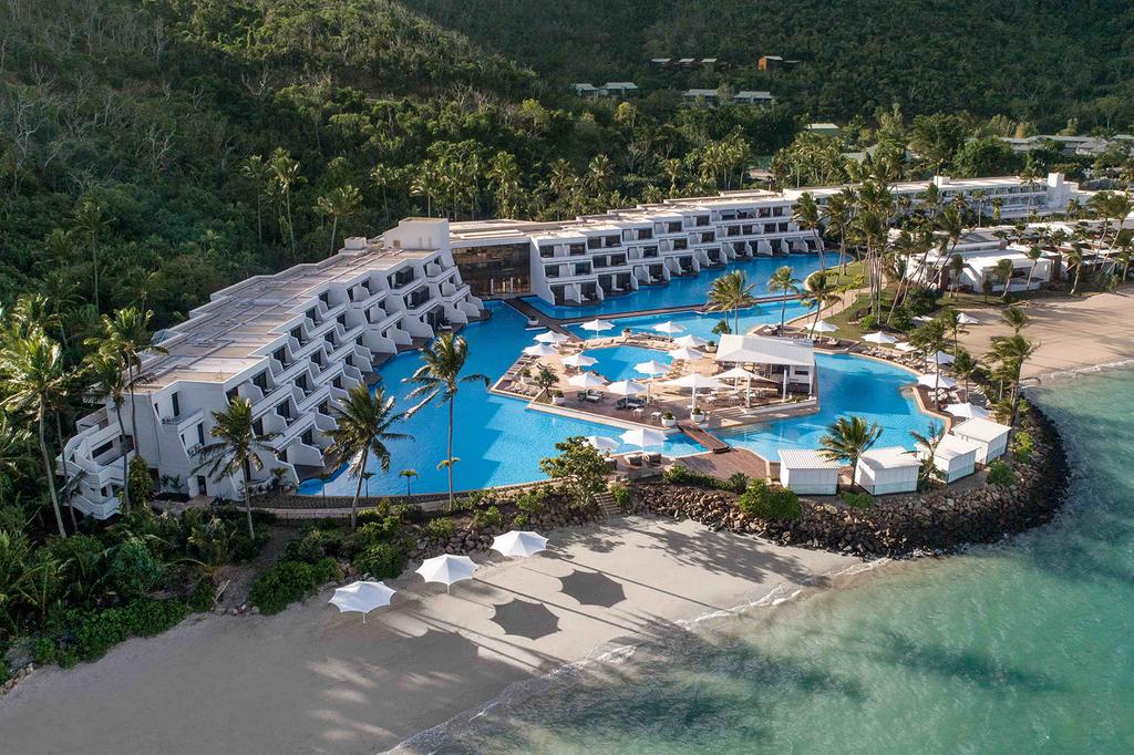 Aerial view of luxurious Hayman Island resort with large pool and ocean access. 