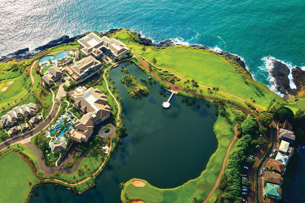 Aerial view of luxury Hawaiian resort with oceanfront golf course and infinity pool.