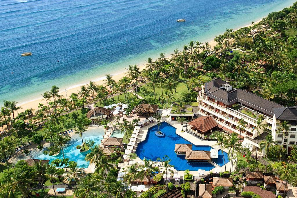 Aerial view of Nusa Dua beachfront resort with pools and gardens.