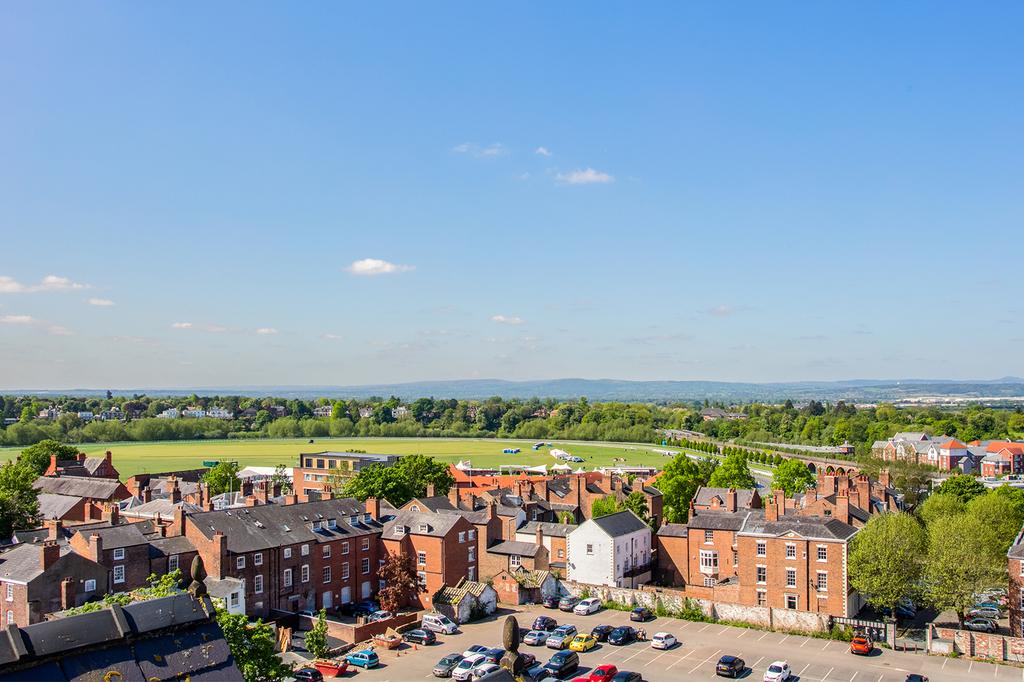 View over Chester with historic buildings and distant green fields.