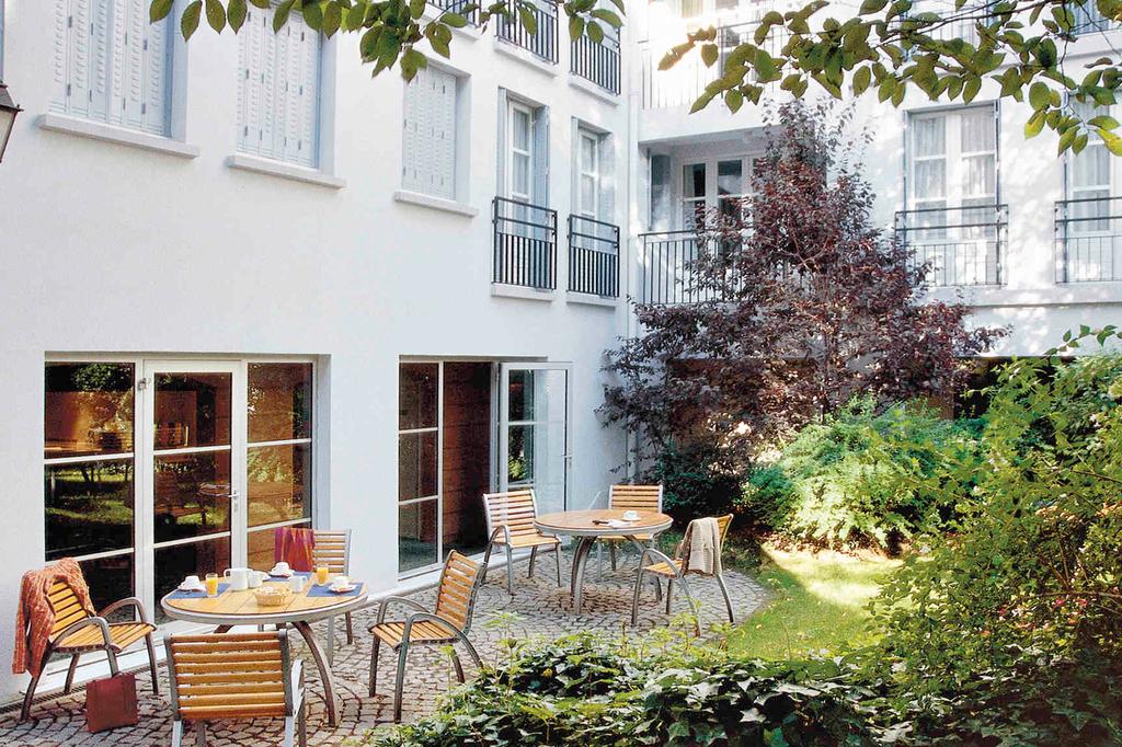 Quaint interior garden of Paris Montmartre apartment with outdoor seating.