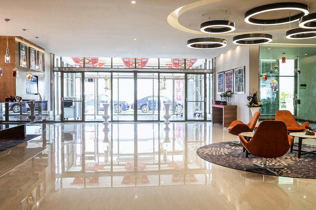 Modern hotel lobby with stylish chairs and large glass entrance.