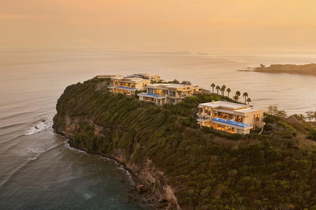 Oceanfront luxury retreat on Grenada's cliffside at sunset.