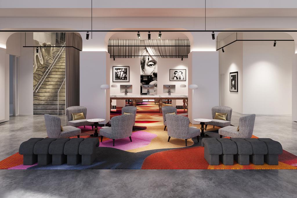 Modern hotel lobby with stylish seating and colorful carpet.
