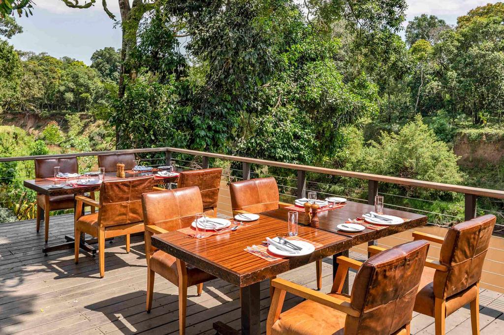 Outdoor dining area overlooking lush greenery in a safari retreat.