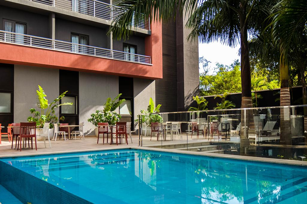 Glistening pool at Crowne Plaza Dar Es Salaam, surrounded by tropical greenery.