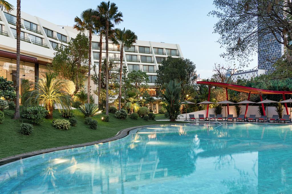 Luxurious Mövenpick BDMS Wellness Resort Bangkok with tropical gardens and a tranquil pool.