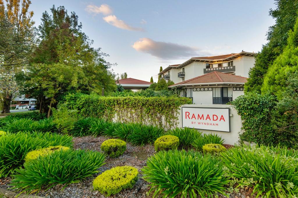 Ramada by Wyndham hotel surrounded by lush greenery in Canberra.