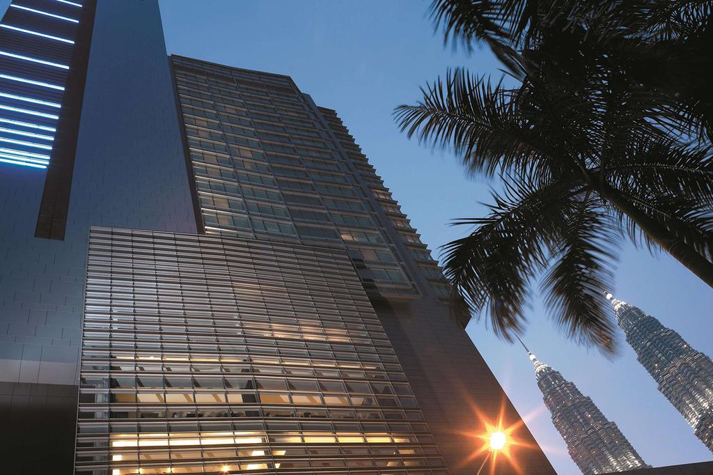 View of Traders Hotel Kuala Lumpur near Petronas Twin Towers at dusk.