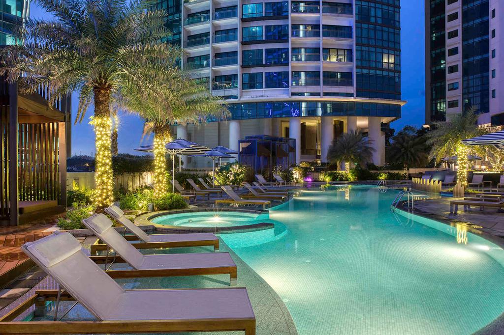 Luxurious outdoor pool at Sofitel Kuala Lumpur Damansara at night.