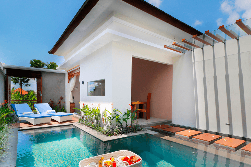 Private pool villa in Seminyak with sun loungers and dining space.