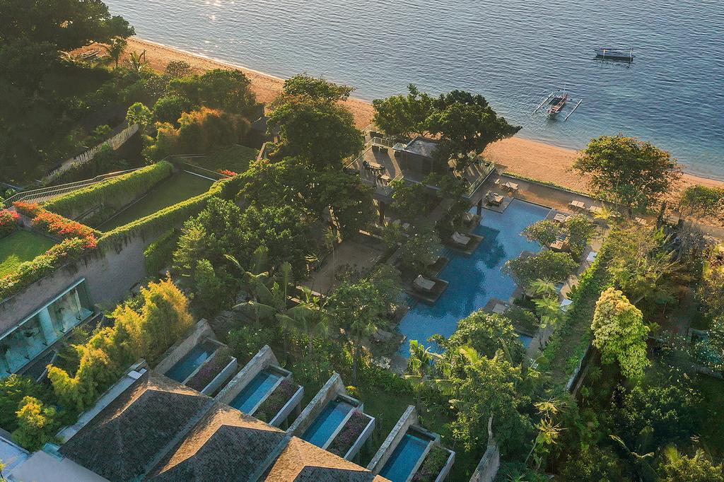 Aerial view of eco-luxury beachfront resort with rooftop gardens.
