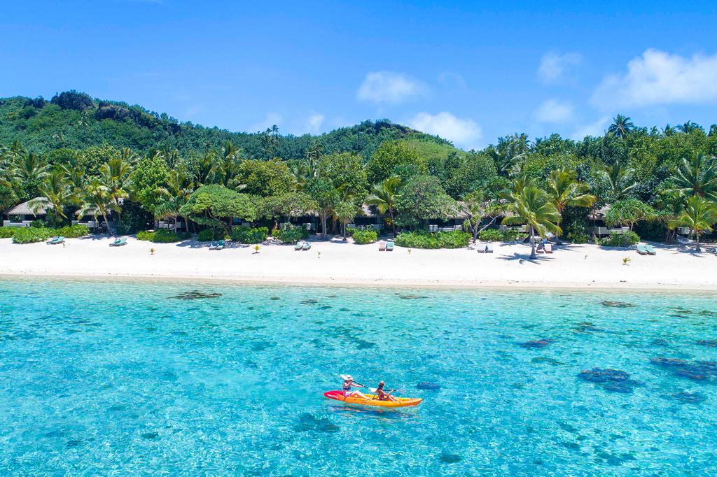 Kayakers on a crystal-clear lagoon near Pacific Resort Aitutaki.