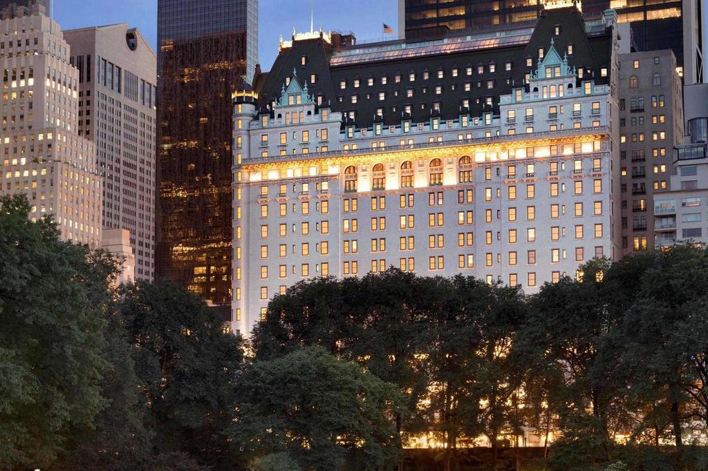 Elegant hotel overlooking Central Park with illuminated historic architecture.