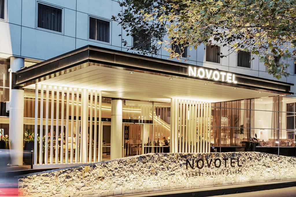Exterior of Novotel Sydney Darling Square at night.