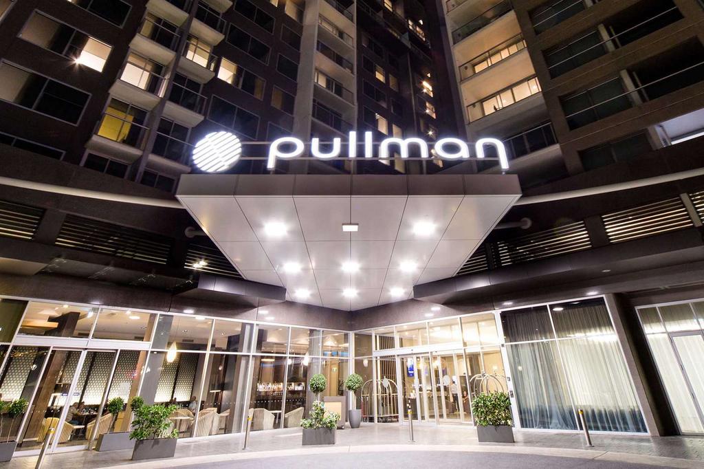 Entrance of the Pullman Adelaide at night, showcasing its modern design.