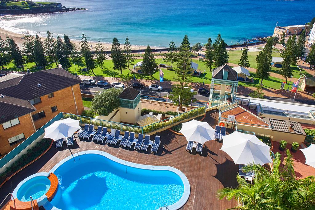 Rooftop pool with views of Coogee Beach and coastline.