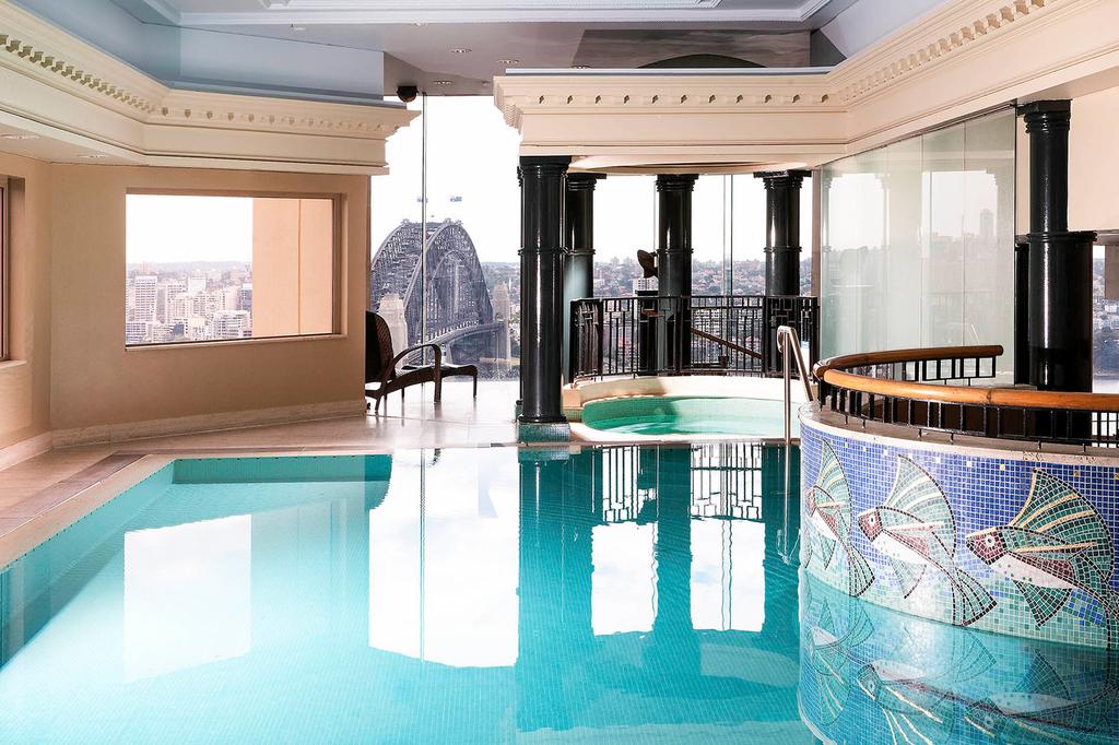 Indoor pool with Sydney Harbour Bridge view at a luxury apartment.