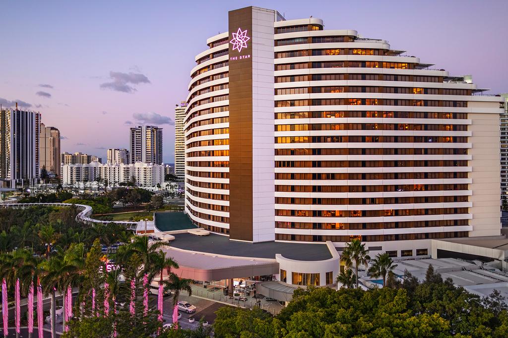 The Star Grand at The Star Gold Coast at dusk with city skyline.