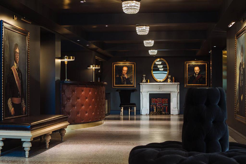 Lobby of Kimpton Palladian Hotel with elegant portraits and chic decor.