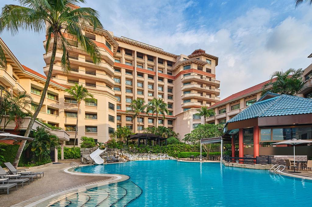 Luxury resort in Clarke Quay with outdoor pool and lush surroundings.