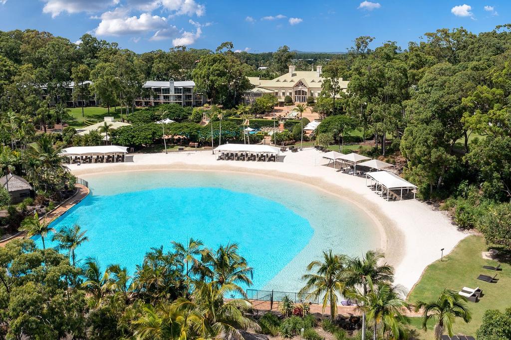 A luxurious lagoon pool at InterContinental Sanctuary Cove Resort, an IHG Hotel with tropical gardens.