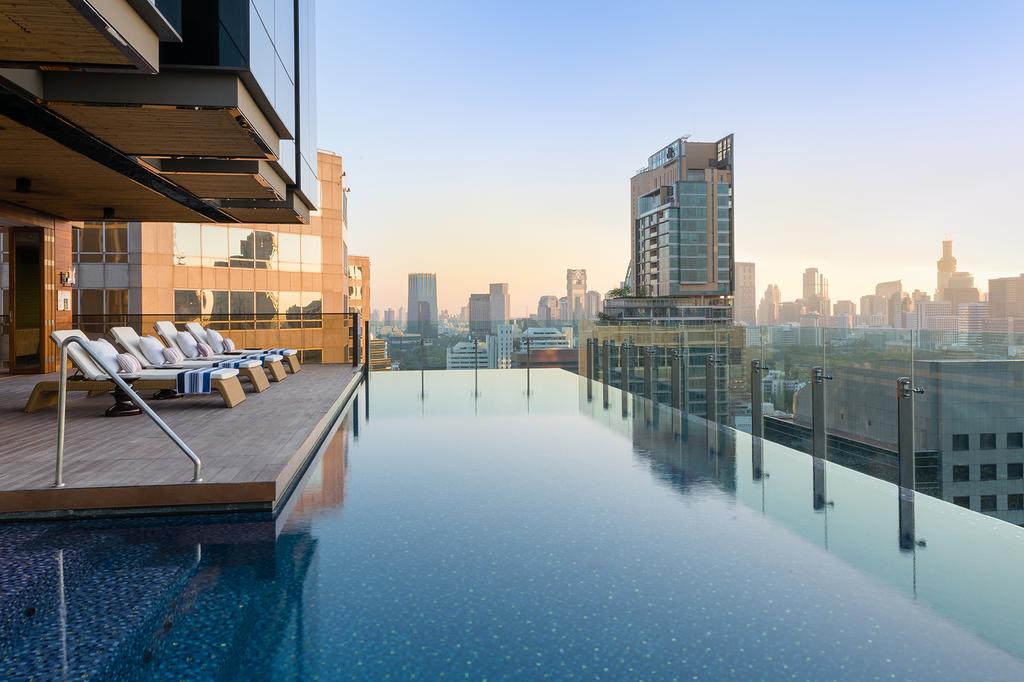 Rooftop infinity pool with city skyline views at Hotel Indigo Bangkok.