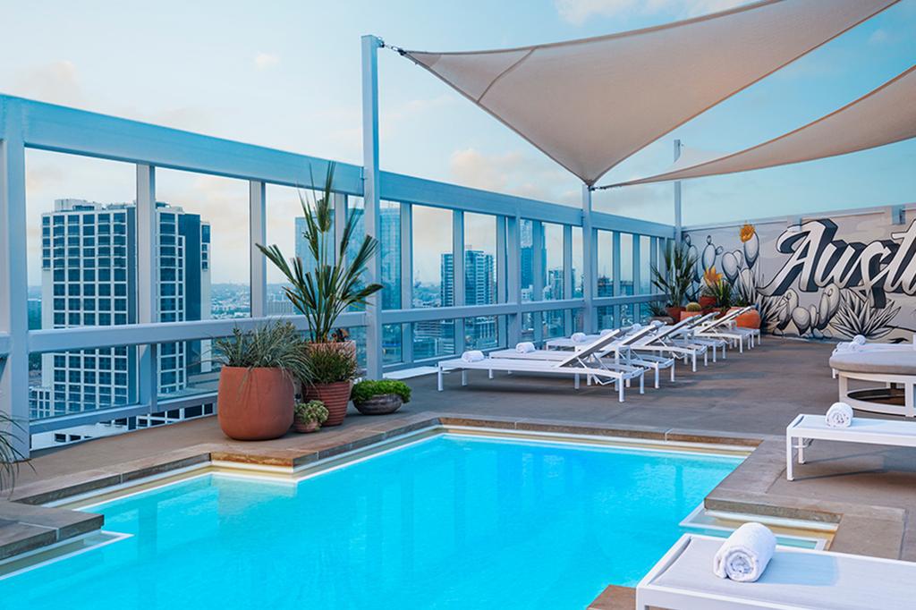 Rooftop pool with city skyline view at a modern Austin hotel.