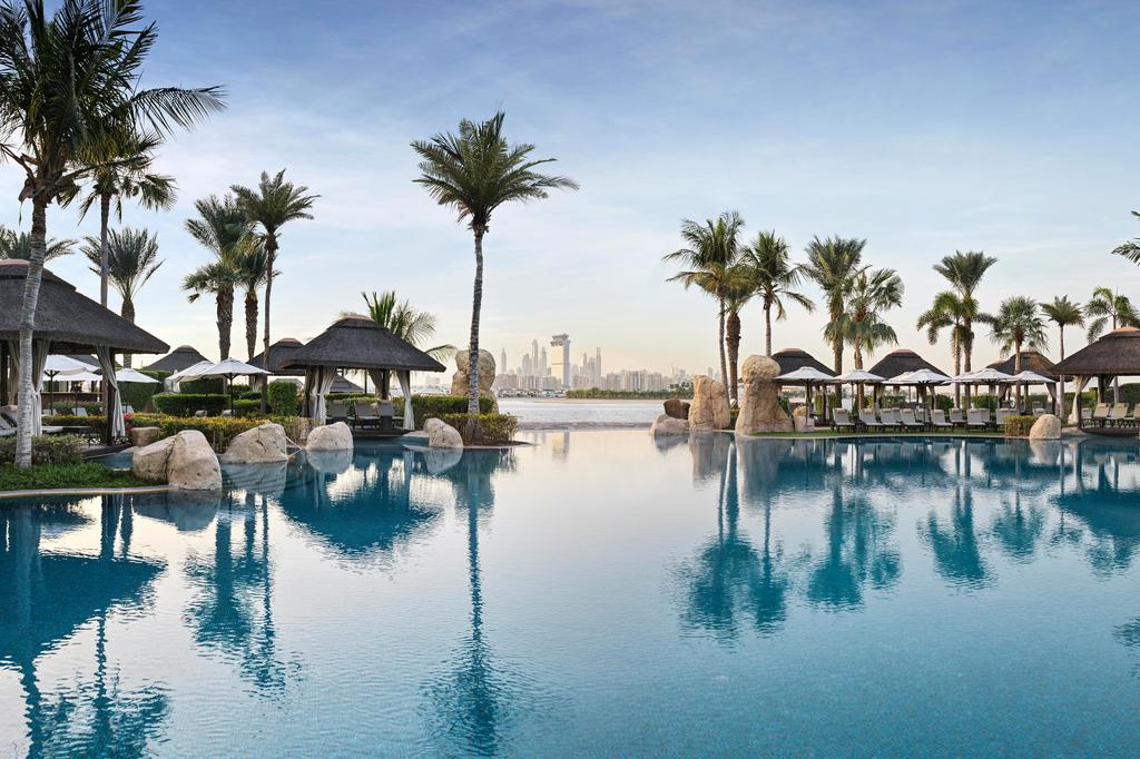 Luxurious pool at Sofitel Dubai The Palm with city skyline view.