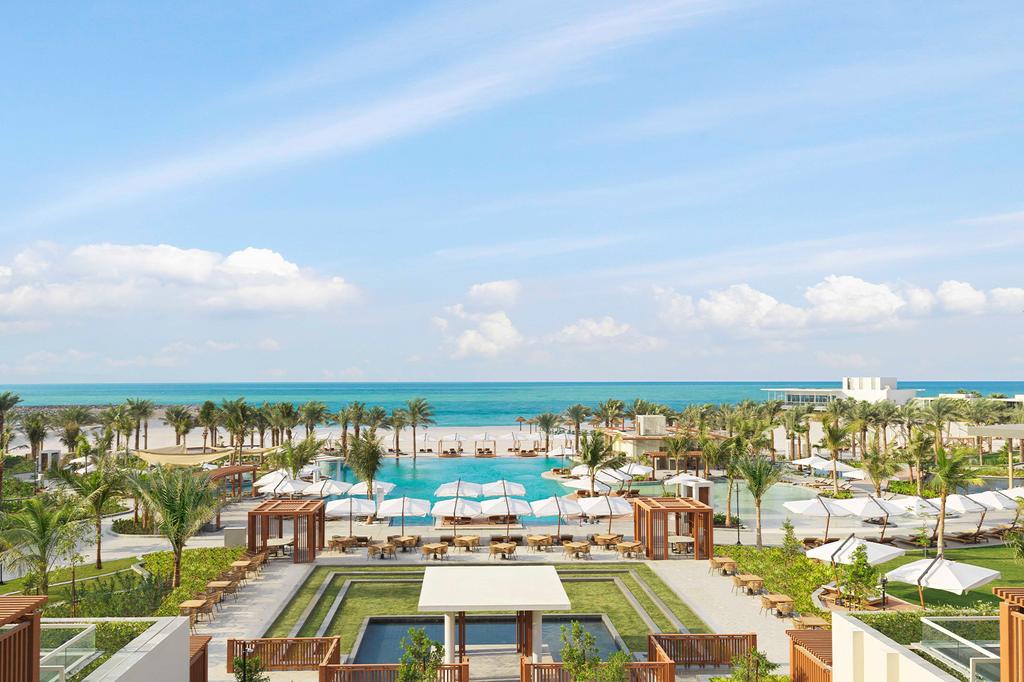 Beachfront view of InterContinental Ras Al Khaimah Resort with pools and palm trees.