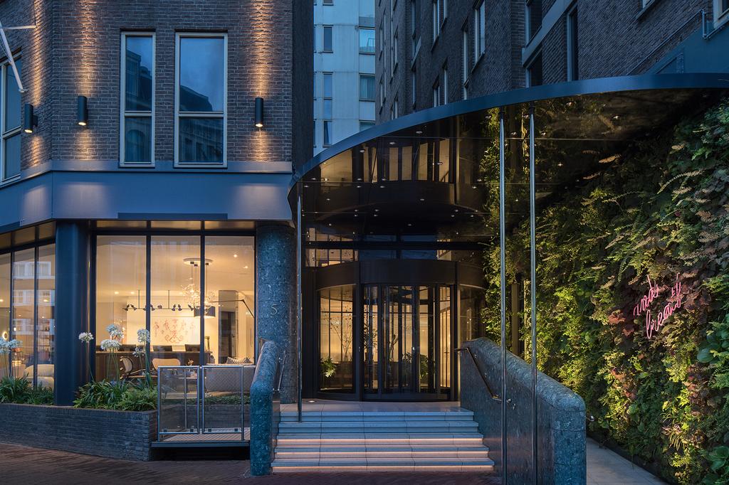 Entrance of Kimpton De Witt Hotel in Amsterdam at dusk.