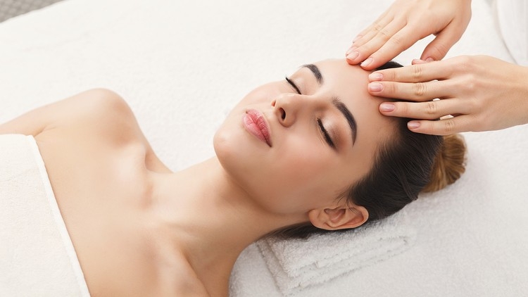 Close up of woman's face receiving a head massage