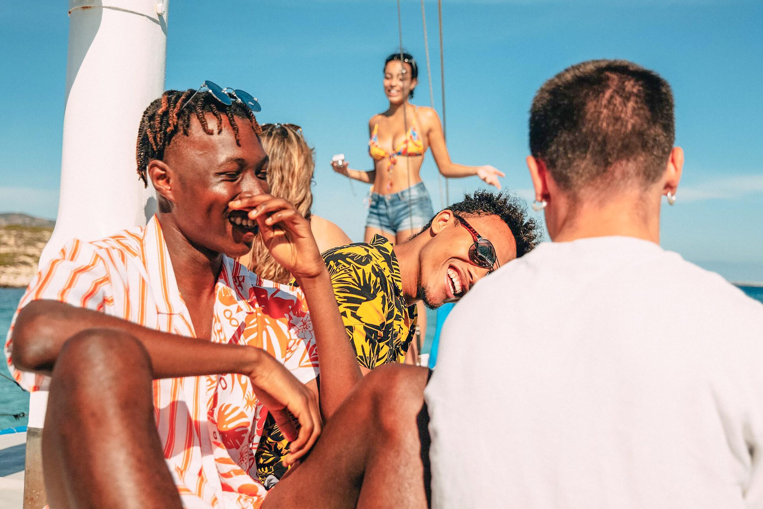 Group of travellers laughing and smiling on the coast of Greece