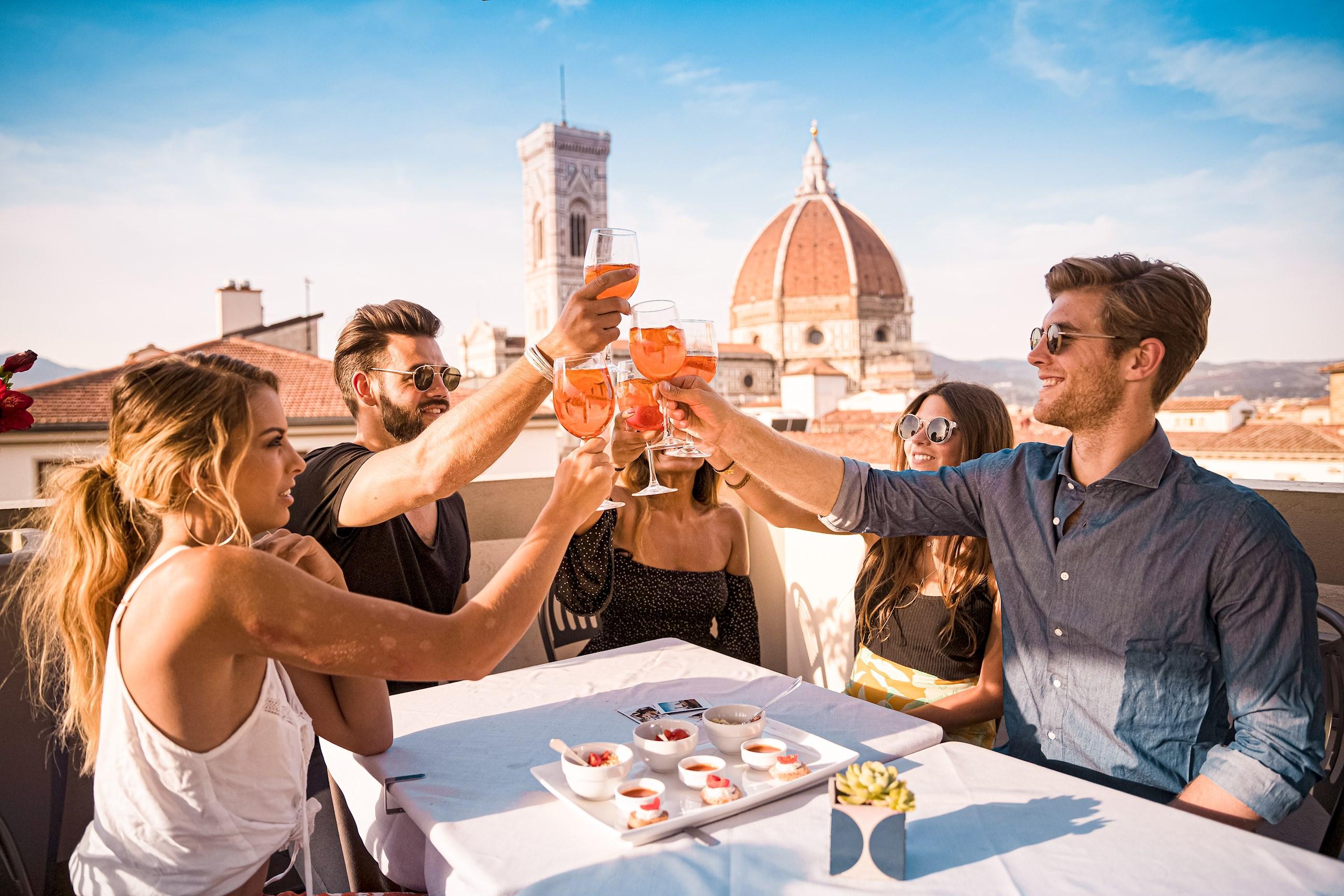 Travellers enjoying aperitive on rooftop in Italy